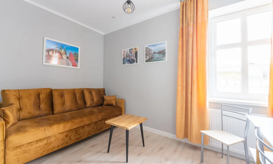 Musztardowa sofa przy oknie