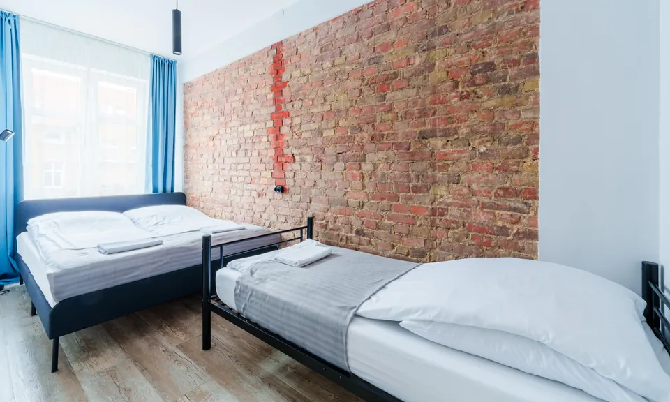 Bedroom with brick wall and beds