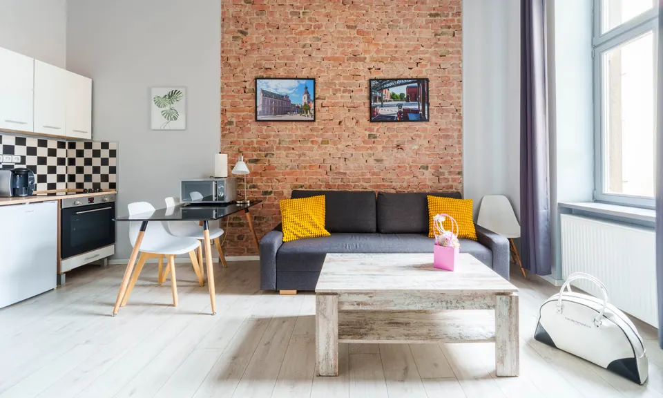 Studio z ceglaną ścianą, sofą i stolikiem kawowym